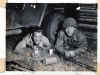 2 Soldiers Sitting Beneath Vehicle