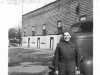 Uniformed Man In Front of Car and Building